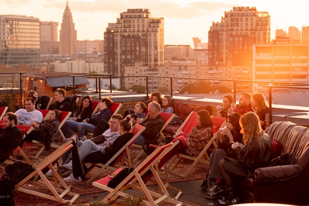Friends laughing together on a rooftop patio at sunset in downtown Toronto